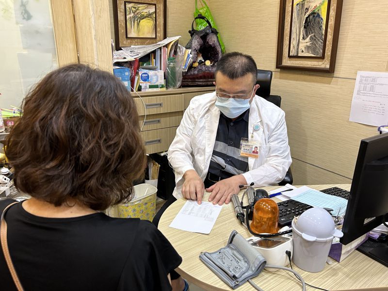 台中市診所醫師施勝桓（右）向女老師（左）說明抽血檢測結果。記者趙容萱／攝影
