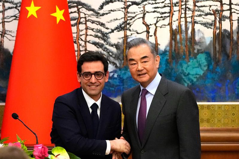 大陸外長王毅1日上午在北京會見到訪的法國長塞儒內。（美聯社）
