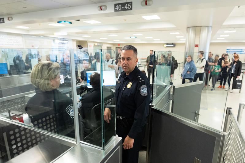 圖為美國海關與邊境保護局官員日前在華盛頓杜勒斯國際機場入境處，觀察及了解旅客入境程序。（美聯社）