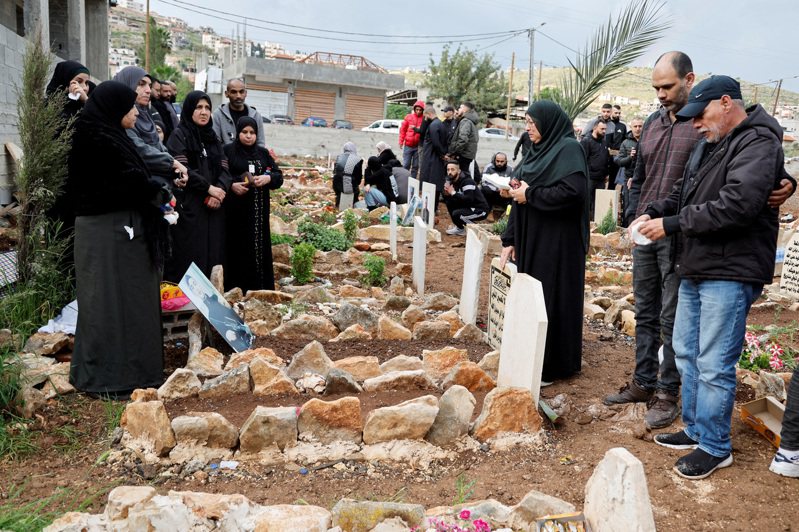 圖為巴勒斯坦人10日在加薩探訪被以色列殺害的親人墳墓。路透