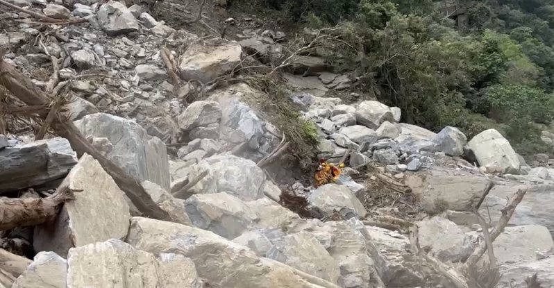 花莲县消防局人犬昨天下午在砂卡礑步道搜寻时，遇到落石，就地倚靠大石头避难，今天又遇到崩塌。图／花莲县消防局提供