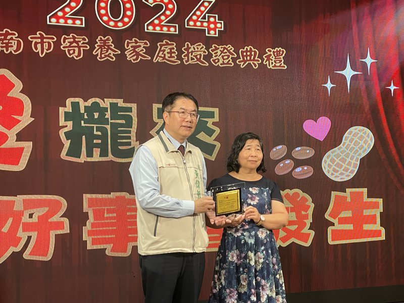 台南市長黃偉哲（左）今表揚服務已屆滿5、10、15、20、25年以上的13戶寄養家庭，肯定其長期以來對寄養兒少的用心與付出。記者萬于甄／攝影