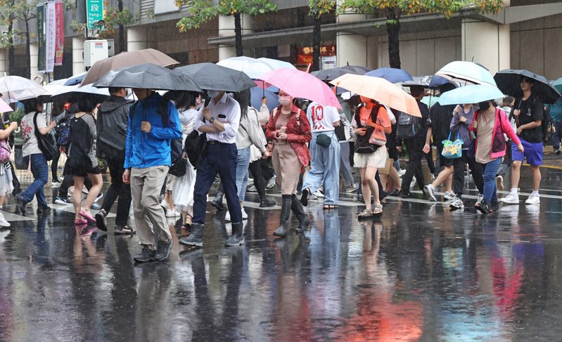 新北今天清晨下起傾盆大雨，雨勢持續到上班、上學交通尖峰時段，不少步行的通勤族與學生，即使撐傘也難以完全抵擋雨勢。記者杜建重／攝影
