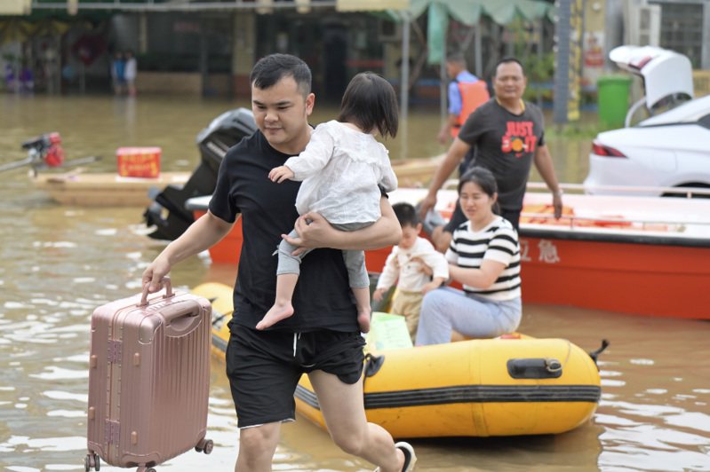 受持續強降雨影響，廣東省北部的韶關市和清遠市出現洪澇災情。圖為廣東省清遠市英德市居民乘划艇離開。 中新社