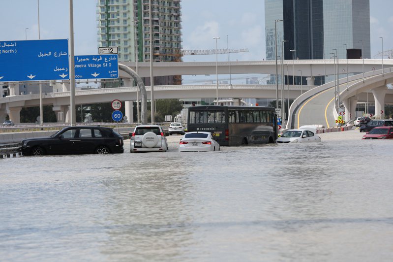 杜拜豪雨造成公路淹水，不諳雨中行車的駕駛打滑碰撞，另有車輛泡水故障，交通打結。(圖／歐新社)