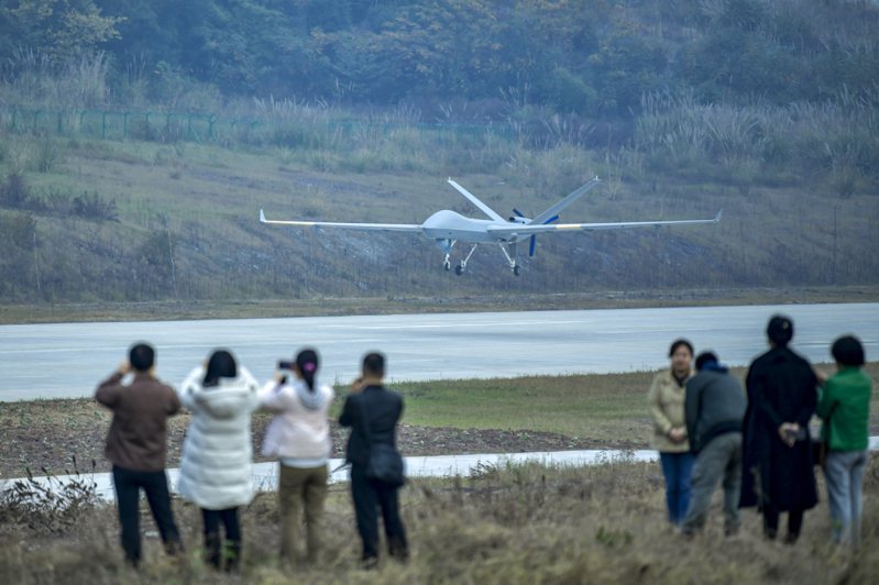 大陸翼龍-2無人機貨運物流日前首飛試驗成功。圖為起飛的翼龍-2無人機吸引參觀者拍攝。（ 中新社）