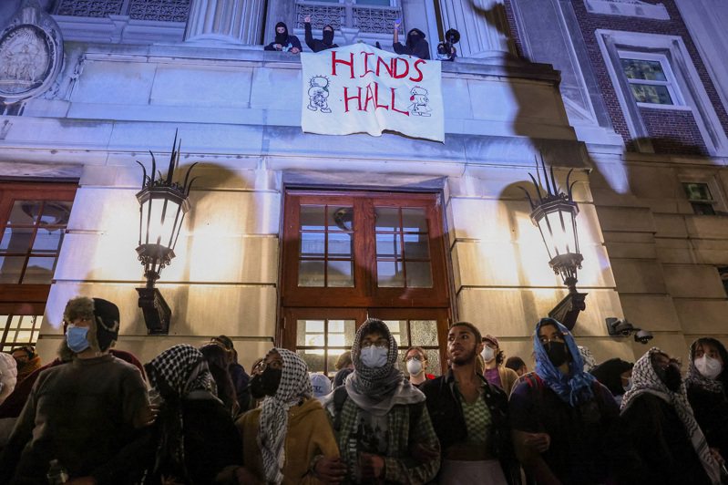 示威者30日凌晨在美國紐約市哥倫比亞大學漢彌爾頓大樓外串起人牆，部分學生占據該大樓封鎖入口。路透社