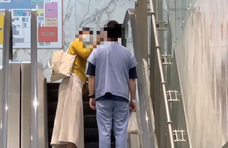 被打的林姓医师（右）在亲友陪伴下搭电扶梯回到办公室。记者刘星君／翻摄