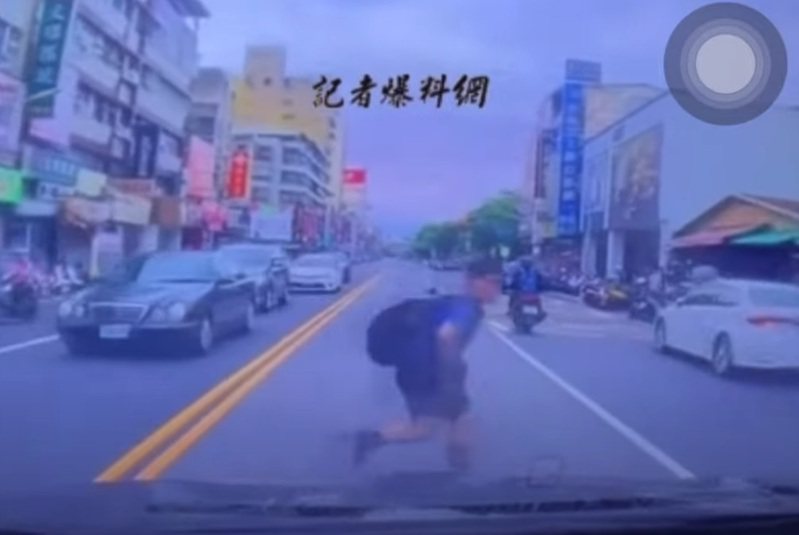 一名背著书包的男童，在马路对向车阵的缝隙中突然钻出，险些被撞。 图／撷自《记者爆料网》影片