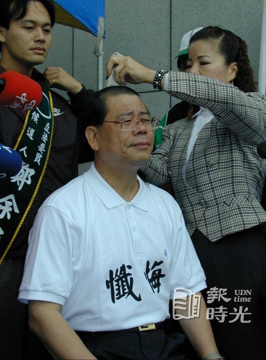 台北縣立委候選人鄭余鎮昨天在縣選委會前，身穿「懺悔」Ｔ恤，當場剃掉頭髮，他說後悔接了「天上掉下來的禮物」，要「從頭做起」。圖／聯合報系資料照 (2004/11/17 雷鳴攝影)
