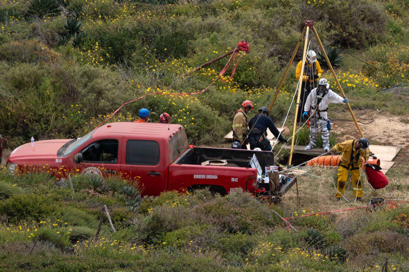 墨西哥下加州日前在偏僻豎井發現3具男屍，5日經家屬指認，證實是來自澳洲和美國的3名衝浪客。圖為警方將遺體從豎井中吊出。法新社