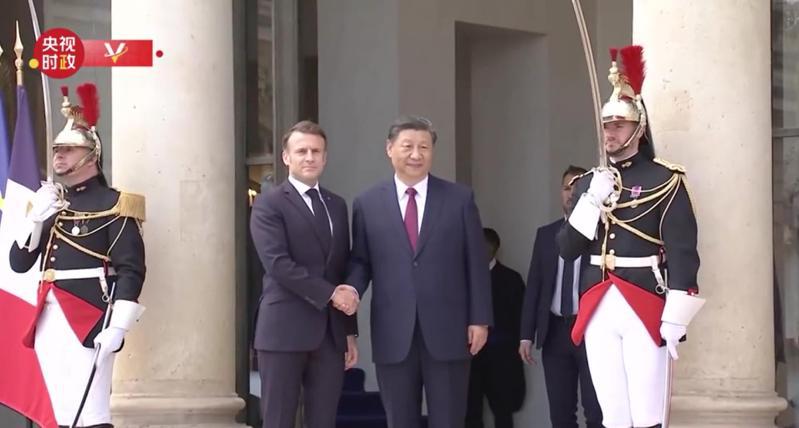 大陆国家主席习近平（中右）抵达爱丽舍宫时，法国总统马克宏出面迎接，两人握手合影。央视