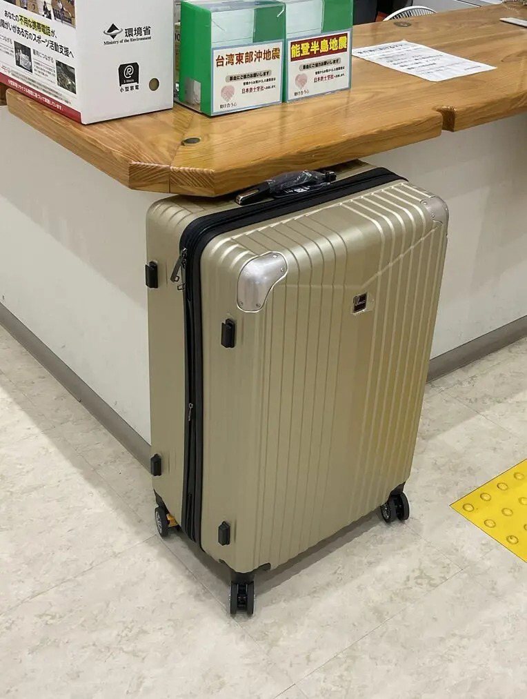 「琉球新报」报导，1个黄色行李箱今天中午前被放在市公所1楼的柜台，市公所广播请物主来领取后，依旧无人认领。 图／撷自那霸市公所