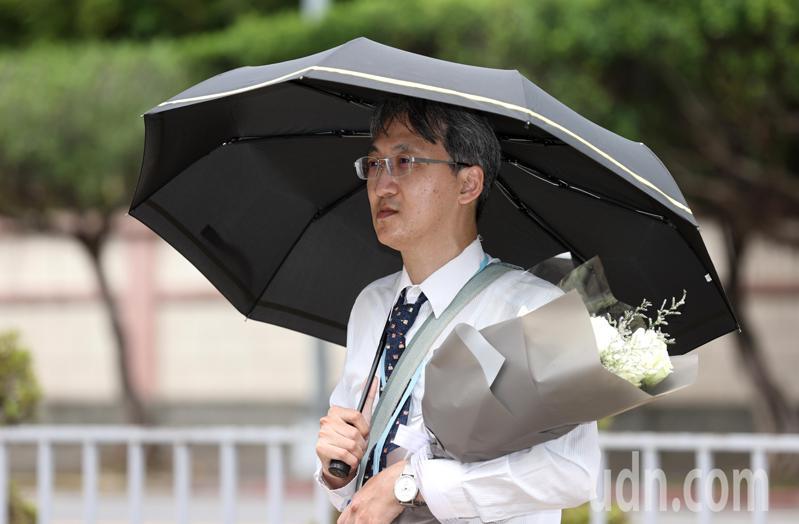 基隆地院法官李岳今天捧著一束白花「伫立」在司法院前广场，不愿向媒体表达诉求，并向媒体表示，没有要发表声明或谈话。记者杜建重／摄影