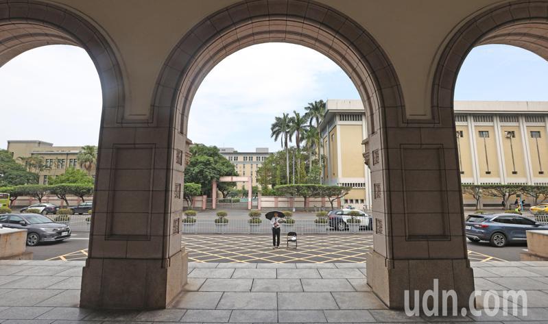 基隆地院法官李岳捧著一束白花、撑著黑伞在司法院前广场「伫立」。记者杜建重／摄影