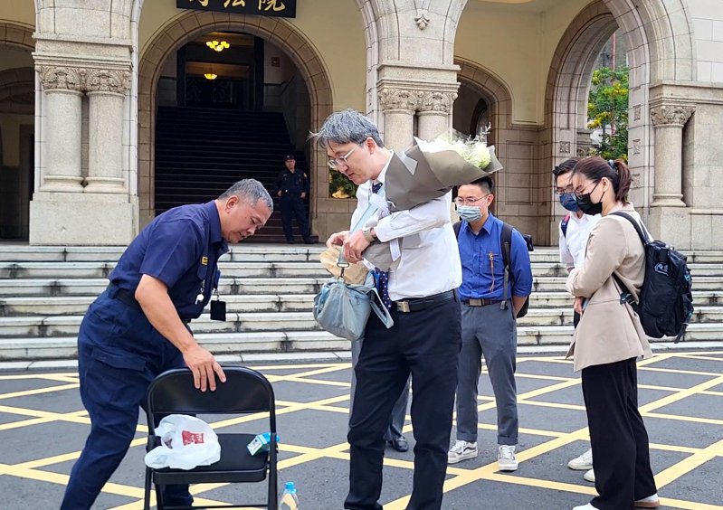 基隆地院法官李岳（左二）今天早上7点半捧著一束白花、撑著黑伞在司法院前广场「伫立」，直到傍晚5点半才离去，足足站了10小时。记者王宏舜／摄影