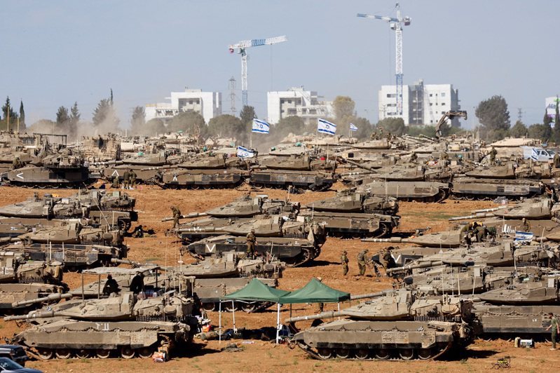 7日在以色列南部與加薩的邊境處，可見不少以色列軍人站在多輛戰車周圍。路透