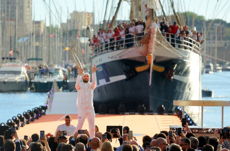 經過12天航行，奧運聖火搭乘百年歷史帆船「貝倫號」，於8日晚間7時駛進法國馬賽港，由饒舌歌手朱爾（Jul）接手點燃巴黎奧運第一個聖火台。 路透