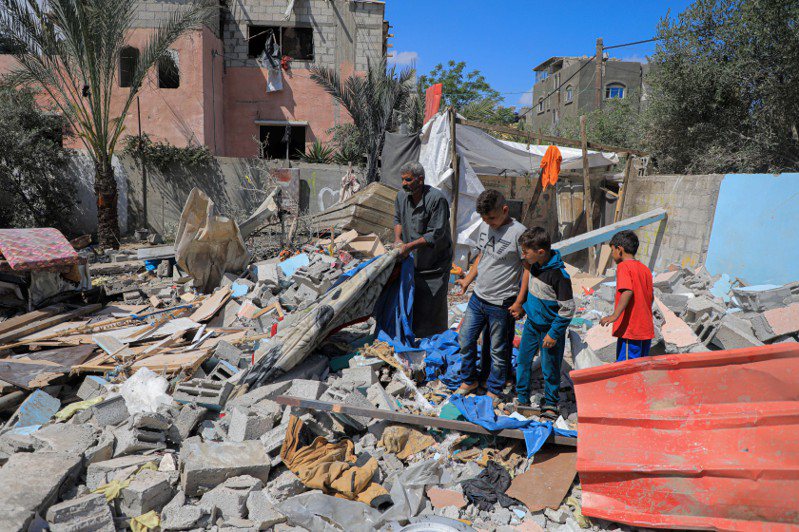圖為加薩地區居民查看轟炸後的廢墟。（新華社）