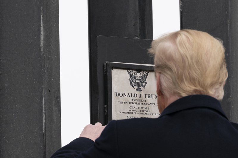 今年1月川普總統離任前特地到美墨邊界所建阻擋無證移民的新建邊牆上，為自己的移民政績簽名留念。如今遭拜登政府廢除。(美聯社)