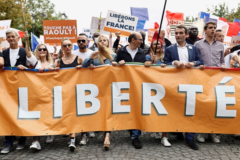 法国各地21日有民众上街示威，抗议政府强行实施「健康通行证」，这是连续第6周的示威活动。图为巴黎游行队伍拿着写有「自由」字样的旗帜和横额。（路透）(photo:UDN)