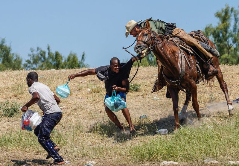 美国边防巡逻员19日骑马在德州美墨边界的格兰德河岸，试图阻止海地无证移民闯入美境。(Getty Images)(photo:UDN)