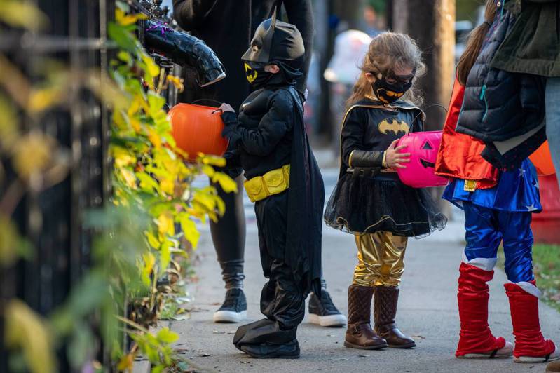 疫情好转，佛奇表示，今年万圣节，孩童可以外出讨糖了，但要记得戴口罩。图为去年万圣节时，纽约市小朋友在家长带领下外出讨糖。(Getty Images)(photo:UDN)