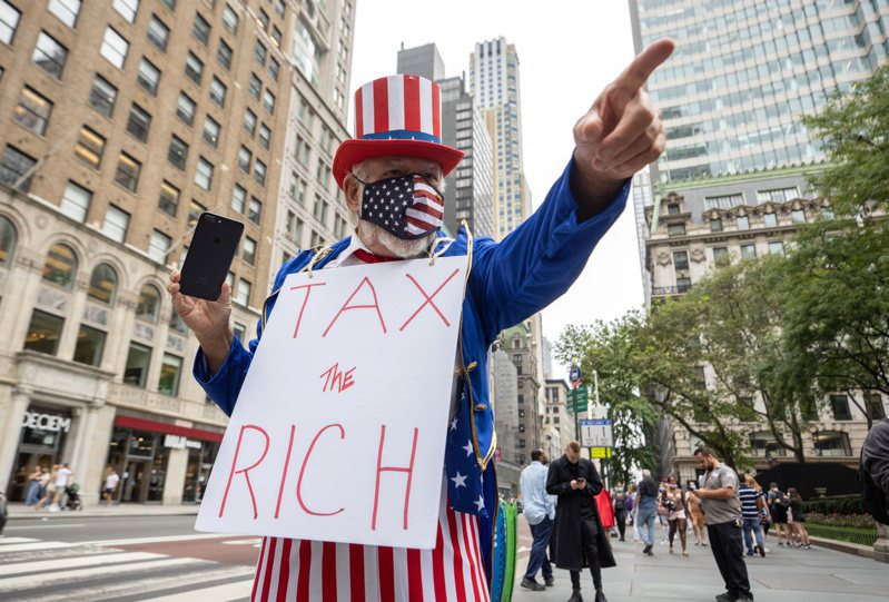 图为民众打出「向富豪征税」的标语在纽约市示威。（路透)(photo:UDN)