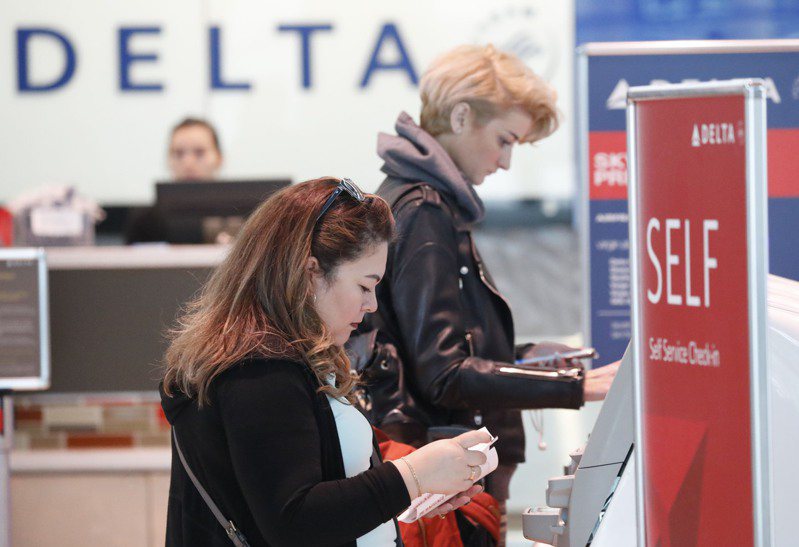 达美航空(Delta Air Lines)日前为解决班机超卖八个座位问题，出价每人1万元之多，让八名乘客自愿下机。图为乘客在达美航空办理登机手续。(美联社)(photo:UDN)