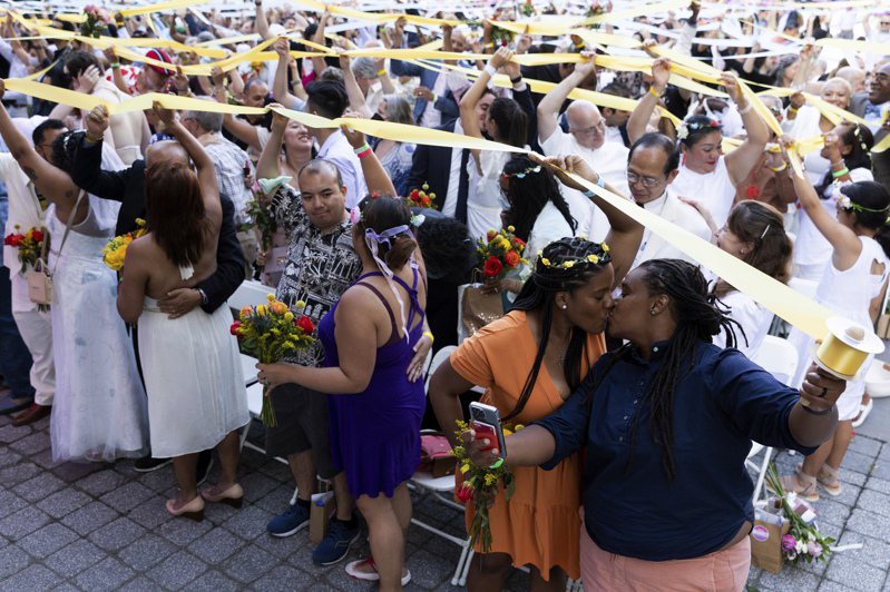 多达四成民众认为新冠疫情已经结束，生活完全回归正常，多数人不再戴口罩。图为纽约新人不戴口罩，在公园举行集体婚礼。(美联社)(photo:UDN)