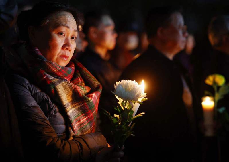 蒙特利公园市持续有民众在临时搭建的灵堂前献花表哀思。图为参加24日晚烛光追悼会的持花民众。美联社(photo:UDN)