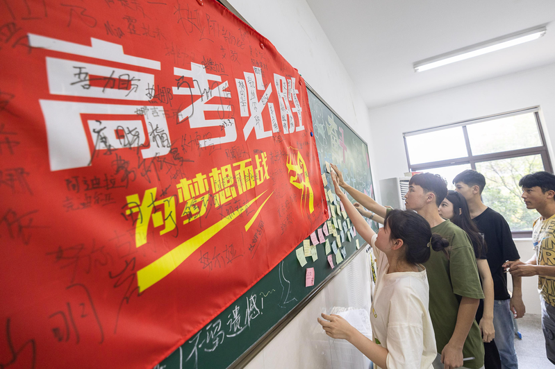 中國今年全國高考報名人數達到1291萬人，圖為浙江湖州一所高中高三學生在黑板貼上高考寄語，為自己打氣加油。（新華社）