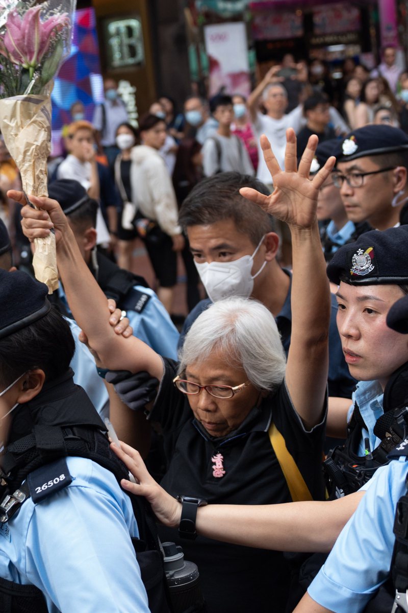 香港警察在維多利亞公園附近的購物區，護送一名拿著鮮花、悼念六四的婦人上警車。（歐新社）