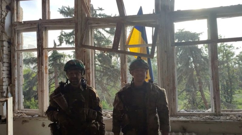 烏克蘭軍隊傳收復頓內次克州布拉霍達特內村，士兵們升起國旗後合影。(路透)
