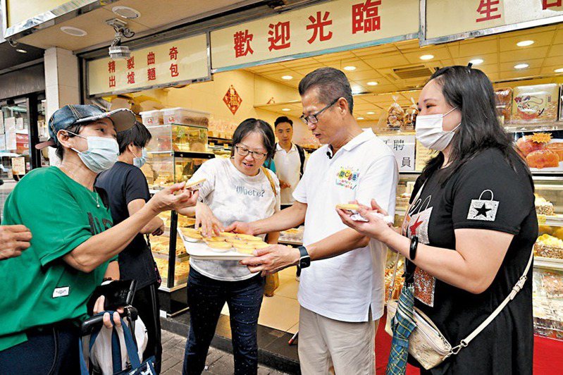 陳茂波（右二）用消費券購買小吃與巿民共享。（取材自陳茂波網誌）