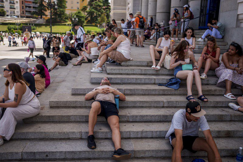 西班牙氣溫飆高，馬德里遊客只能找蔭涼處休息。（美聯社）