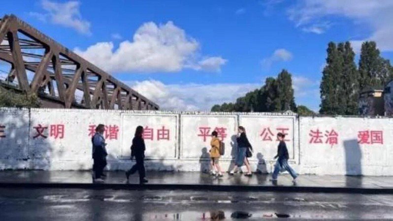 中國留學生在倫敦東區的紅磚巷（Brick Lane）塗鴉牆寫下法治、愛國等中共「社會主義核心價值觀」大紅字，被譏「一秒回中國」，引發海外華人譴責，批評藝術作品被這些可恥的標語覆蓋。(取材自X平台)