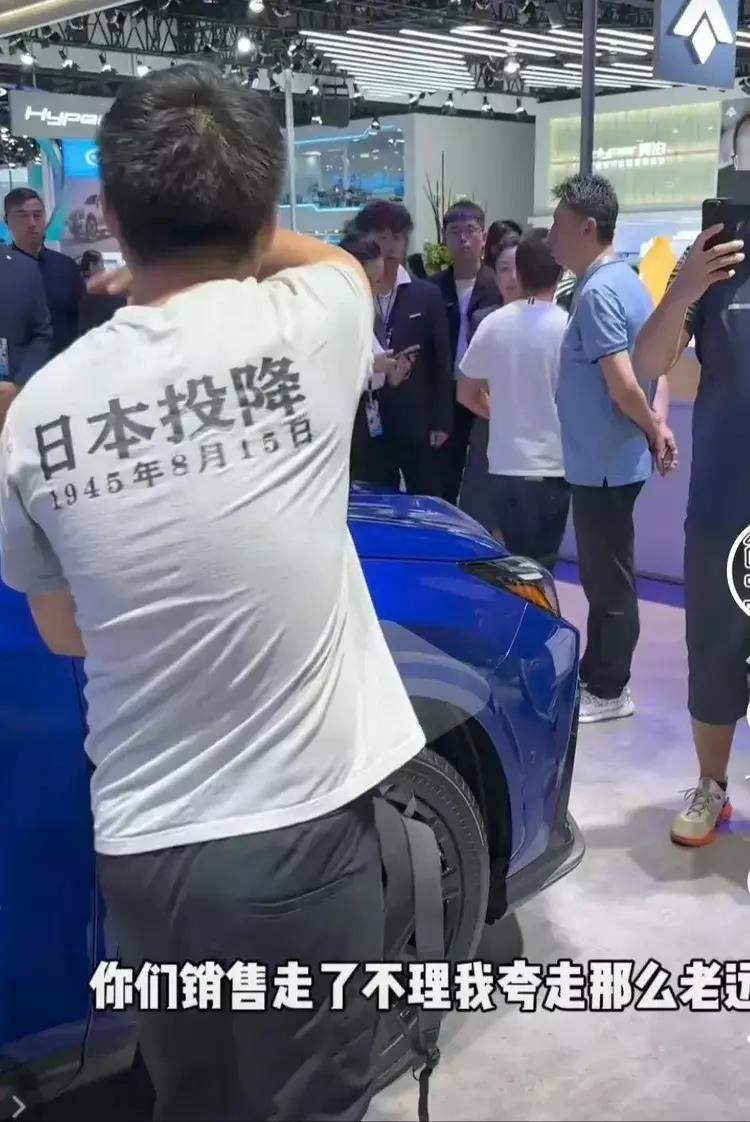 男子著｢日本投降｣衫看日系車展遭轟極端。(視頻截圖)