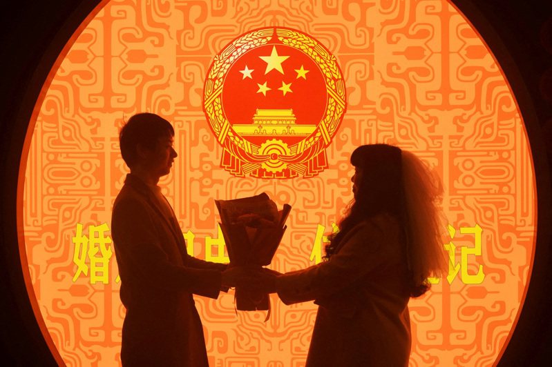 浙江省杭州市婚姻登記處的一對新人在情人節登記結婚。（路透）