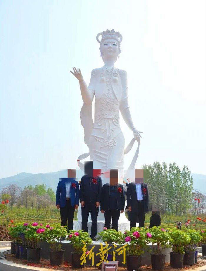 在開園儀式上，當地鎮領導等人站在該雕像下方合影留念。（取材自新黃河）