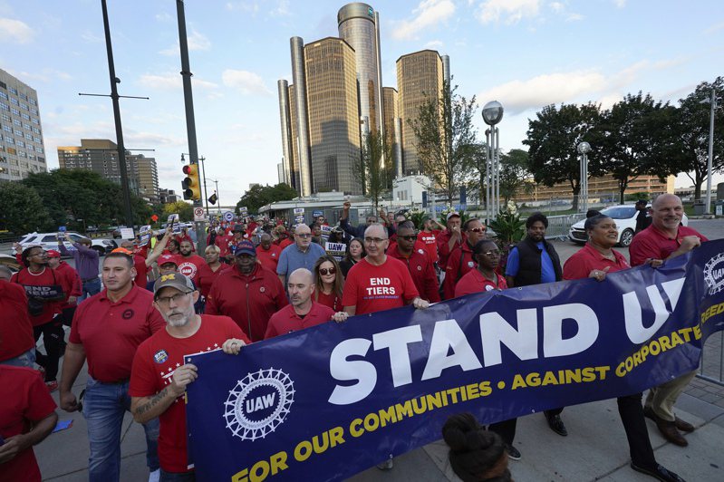 UAW汽車工人持續罷工，工會主席費恩(中)20日與勞工在密西根州底特律市福特汽車總部前示威，並表示22日罷工擴大升級。(美聯社)