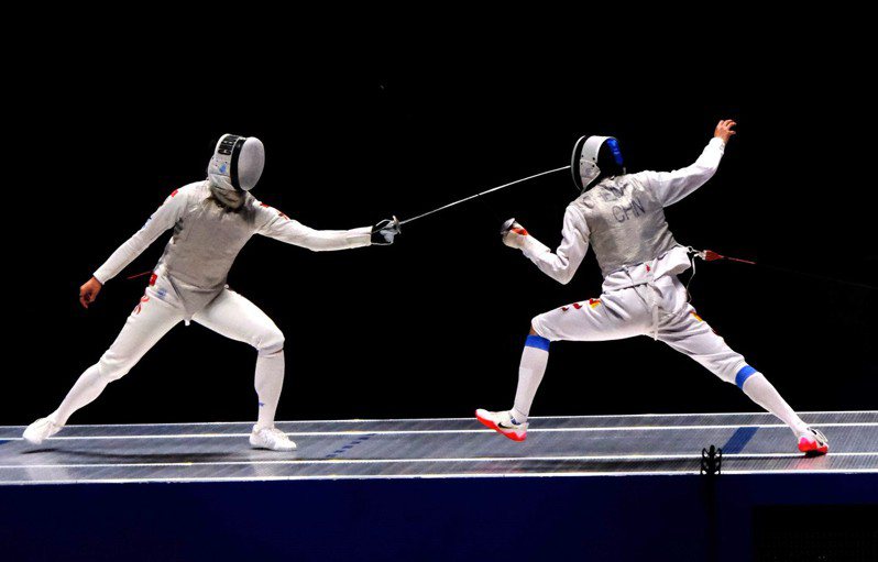 張家朗（左）24日在杭州亞運會花劍決賽擊敗中國劍手，為香港劍擊隊奪得首面金牌。（中通社）