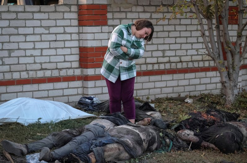 俄軍攻擊烏克蘭哈爾科夫地區造成至少48死，圖為一名婦女下在辨認遺體。（路透）