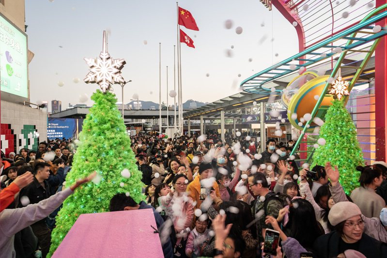 香港市民和遊客24日，在尖沙咀的一處布景前歡度節假日。（中新社）