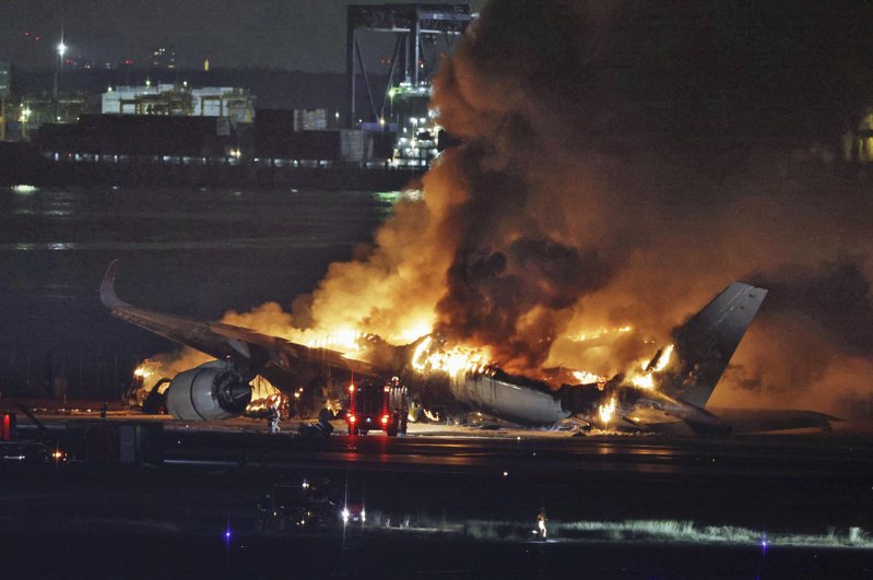 日航客機在羽田機場與海保廳的飛機擦撞後，在跑道上燒成一團大火。（美聯社）