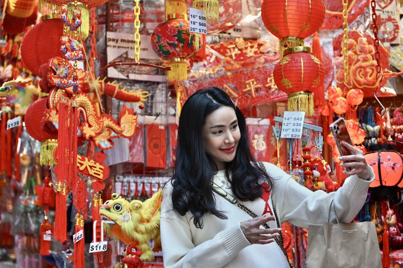 農曆新年即將到來，香港中環石板街的商戶換上賀年裝飾，吸引市民及旅客前來選購或拍照，氣氛濃厚。（中新社）