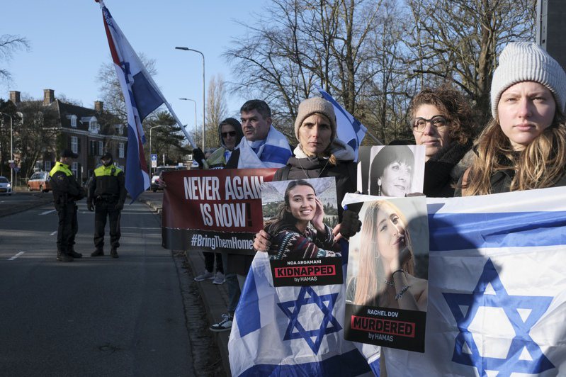 在海牙國際法院外面，挺以色列的民眾舉著以色列國旗及人質照片，要求哈瑪斯釋放擄走的以色列人質。(美聯社)