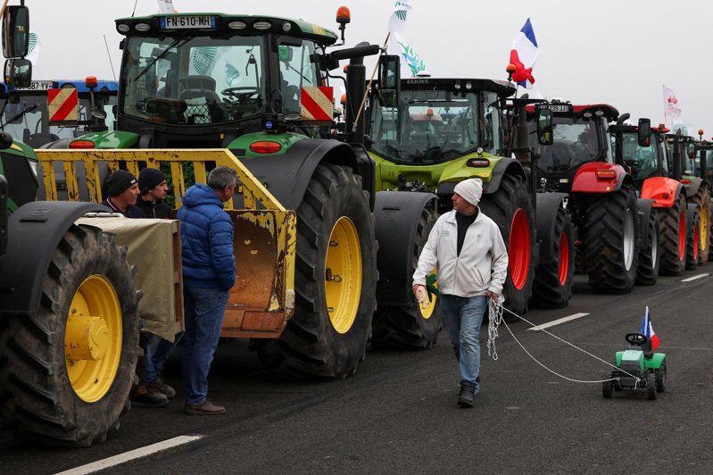 法國巴黎附近的農民推著拖拉機行走，抗議價格壓力、稅收和綠色監管，並指出這些都是歐洲各地農民共同的不滿。（路透）