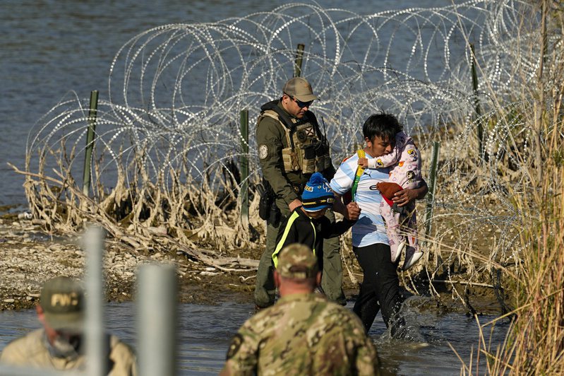 每天數以千計的大批無證客自墨西哥邊界湧入德州，即使邊防巡邏隊放置鋒厲鐵絲網，都無法攔阻無證客涉水進入邊城伊戈帕斯。(美聯社)