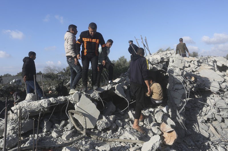 以色列10日空襲加薩南部的拉法市，至少造成44名巴勒斯坦人死亡。圖為民眾在廢墟中搜尋生還者。(美聯社)